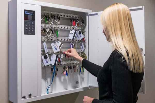 woman placing keys into a secure key management system