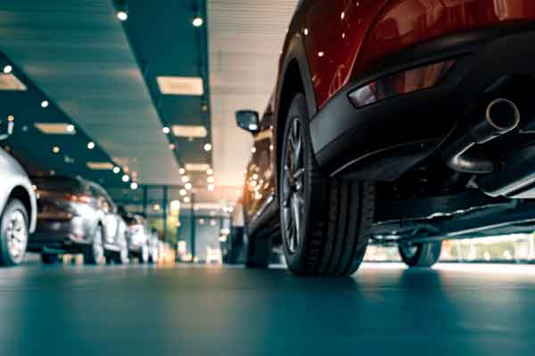 Low angle shot of the underside rear of a red car in a dealership.
