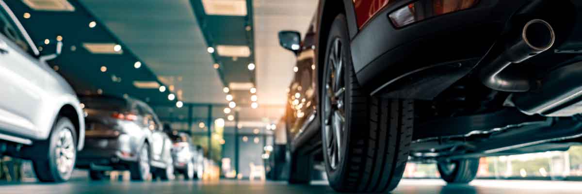 Car dealership as seen from behind a red car.