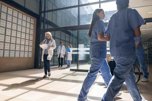 Shot of a lobby with nurses and doctors walking.